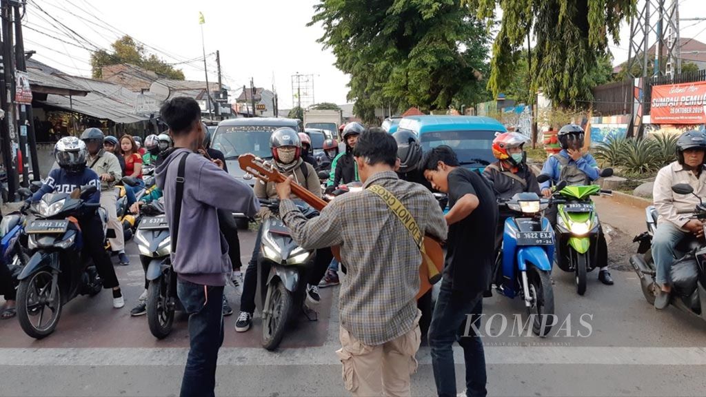 Street children in Depok, West Java, busking at a red light intersection, Wednesday (20/11/2019).