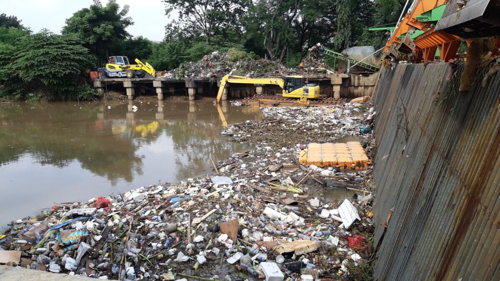 Sampah yang tertahan di saringan kawasan Cengkareng Drain, Kembangan, Jakarta Barat. Seusai hujan pada Minggu dini hari, sampah tersebut masih dalam proses pengangkutan oleh petugas UPK Badan Air.