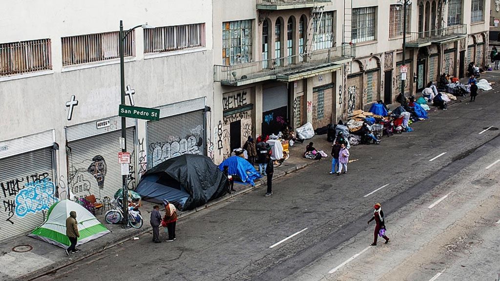Para tunawisma menggelar tenda di trotoar depan Midnight Mission di Skid Row, Los Angeles, California, AS, 19 Maret 2020. AS menyiapkan stimulus pereda guncangan ekonomi akibat Covid-19, termasuk bantuan langsung tunai.