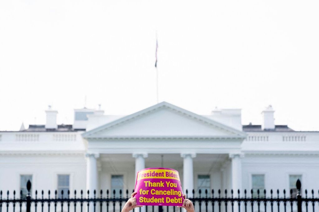Seorang aktivis mengangkat poster berisi pesan ucapan terima kasih terhadap Presiden AS Joe Biden yang mengumumkan keputusan penghapusan utang kuliah dalam unjuk rasa di depan Gedung Putih di Washington DC, AS, Kamis (25/8/2022). 