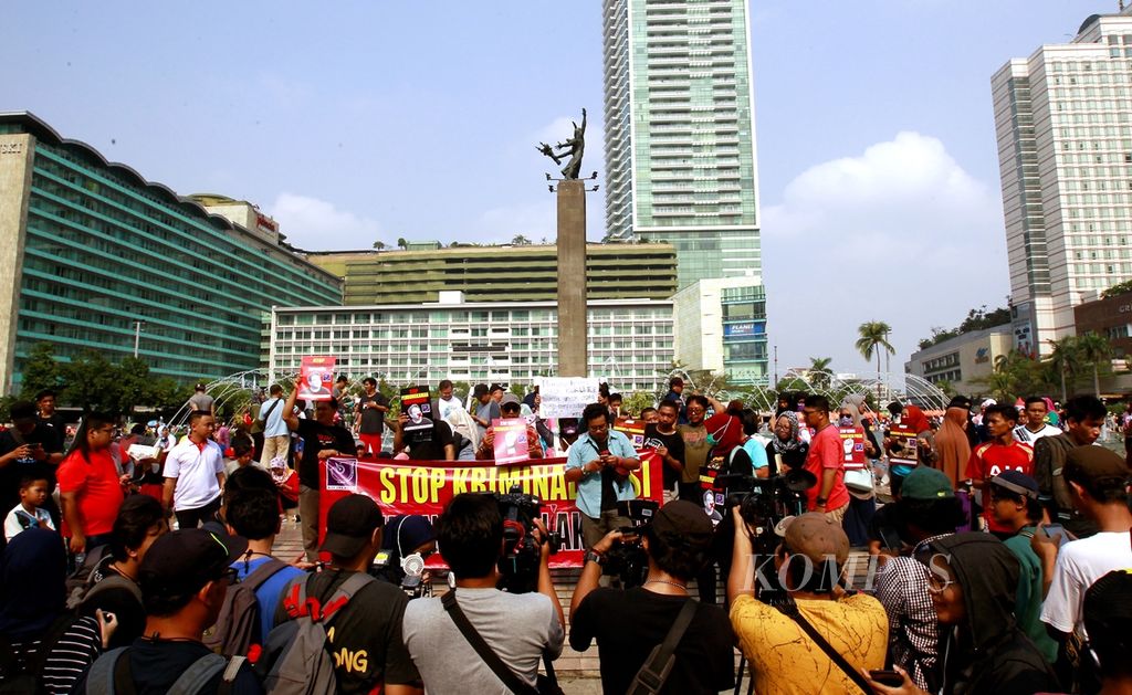 Sejumlah jurnalis menggelar aksi solidaritas di kawasan hari bebas kendaraan bermotor (CFD) Bundaran Hotel Indonesia, Jakarta, Minggu (29/9/2019). Aksi dilakukan sebagai bentuk protes atas penetapan tersangka terhadap jurnalis sekaligus aktivis Dandhy Dwi Laksono.