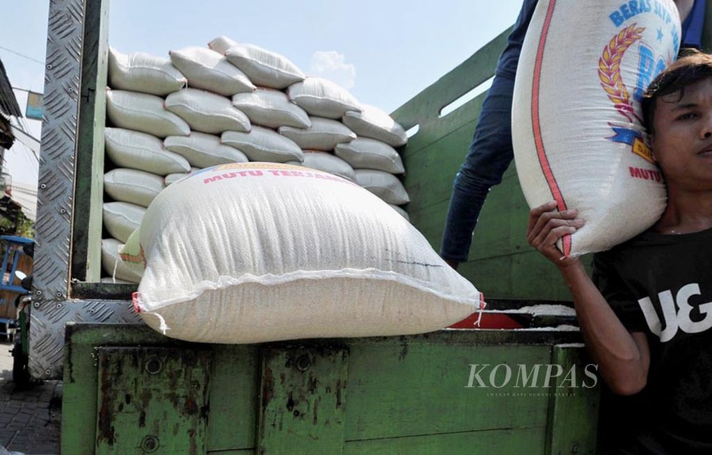 Pekerja menurunkan beras dari  truk pengangkut di salah satu toko pengecer di Kedoya, Jakarta, Jumat (6/10). Pemerintah diharapkan dapat segera menyiapkan stok beras medium di pasaran untuk mengantisipasi lonjakan harga karena suplai yang minim.