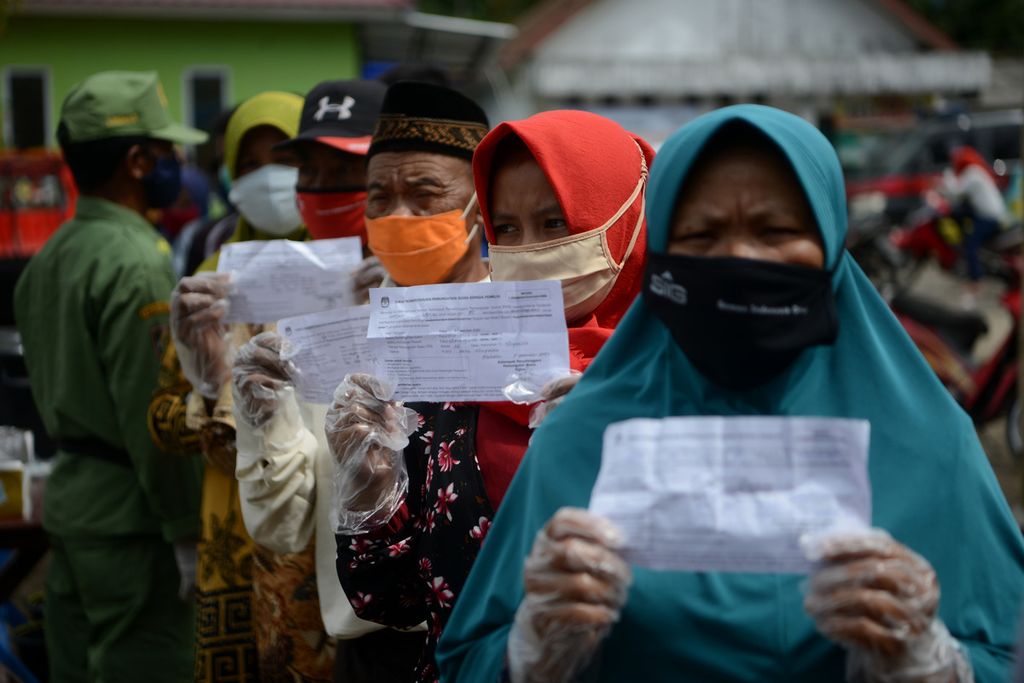 Warga menunjukkan undangan untuk memilih sebelum menggunakan hak pilihnya dalam Pilkada di TPS 06, Desa Tlogolele, Selo, Boyolali, Jawa Tengah, Rabu (9/12/2020).