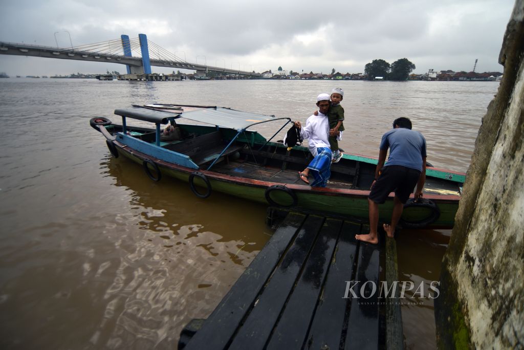 Dengan menggunakan perahu, warga berdatangan untuk mengikuti Ziarah Kubro 2024 di Kampung Sungai Bayas, Kuto Batu, Palembang, Sumatera Selatan, Minggu (3/3/2024). 