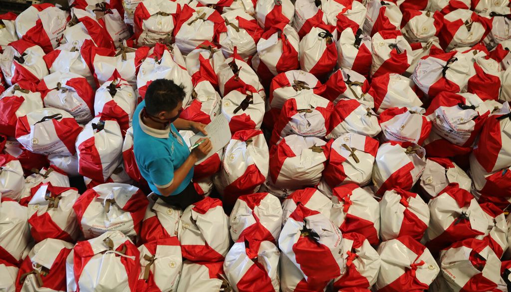 Pekerja mendata paket bantuan sosial (bansos) di Gudang PT Food Station Tjipinang Jaya, Cipinang, Jakarta Timur, Kamis (23/4/2020). 