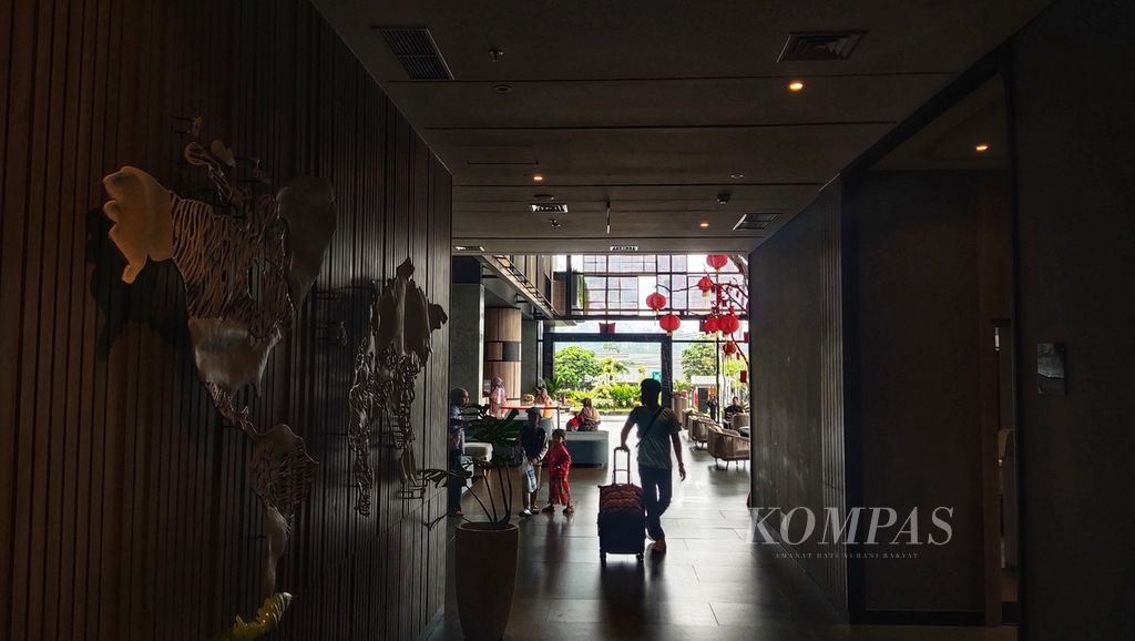Penginap melintasi area lobi di sebuah hotel berbintang yang didirikan di dekat Bandara Internasional Yogyakarta, Kabupaten Kulon Progo, Daerah Istimewa Yogyakarta, Sabtu (10/2/2024). 