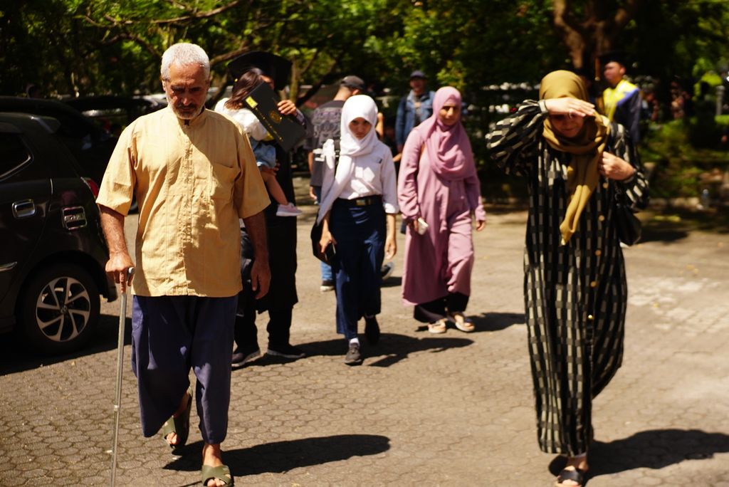 M Yaqub M Karim (61, kiri), Aqila Douraiyah (50, kanan depan), Tahanan PBB II alias Sakinah (12, berseragam), dan Amira Mustafa (50, berbaju merah jambu) berjalan meninggalkan Universitas Sam Ratulangi, Manado, Sulawesi Utara, setelah menghadiri acara wisuda Amar, 9 Februari 2023.