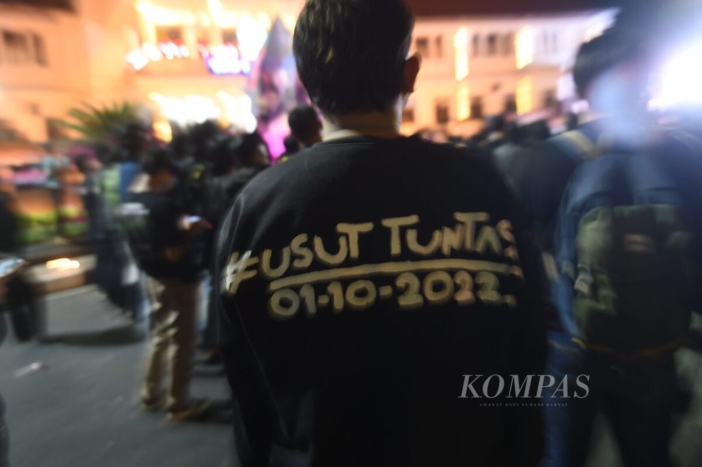 Kaus bertuliskan usut tuntas dipakai Aremania saat doa bersama memperingati satu tahun Tragedi Kanjuruhan di depan Balai Kota Malang, Kota Malang, Jawa Timur, Minggu (1/10/2023). 