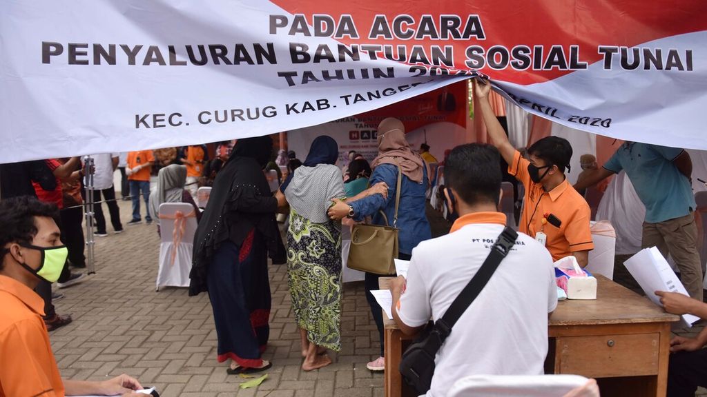 Warga mendatangi Kantor Pos Kecamatan Curug, Kabupaten Tangerang, Banten, untuk mencairkan bantuan sosial (bansos) tunai, Sabtu (25/4/2020).