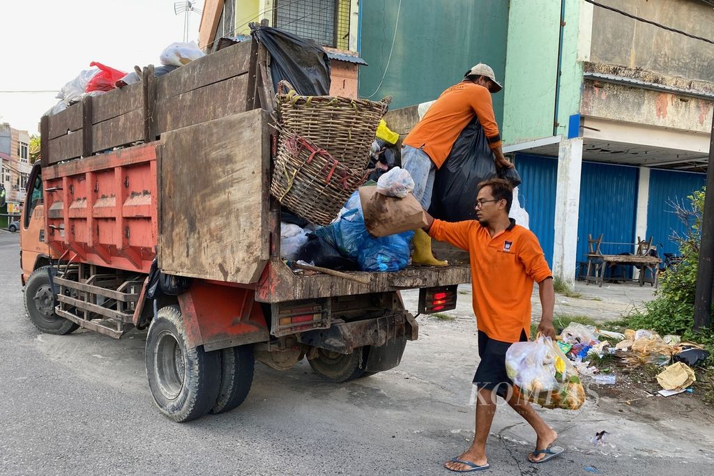 Petugas menaikkan kantung-kantung sampah ke atas truk di kawasan Pondok, Kota Padang, Sumatera Barat, Jumat (16/6/2023) pagi. Sampah hingga saat ini masih menjadi persoalan di berbagai kota, termasuk Kota Padang.