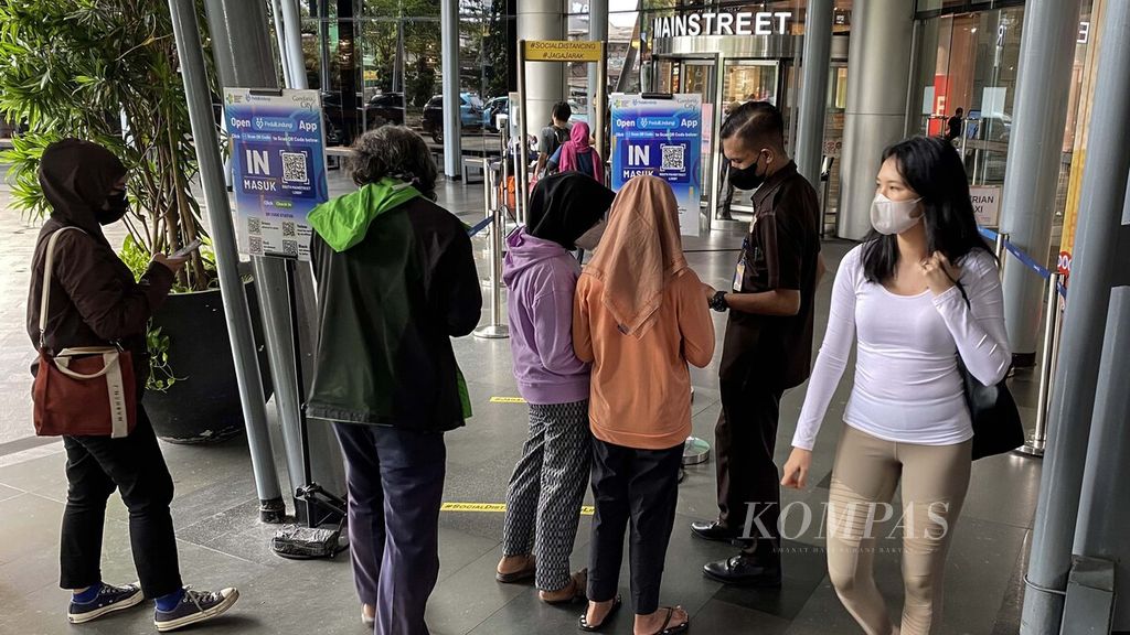 Pengunjung memindai kode batang dalam aplikasi Peduli Lindungi saat akan memasuki Mal Gandaria City, Jakarta Selatan, Desember 2021. 