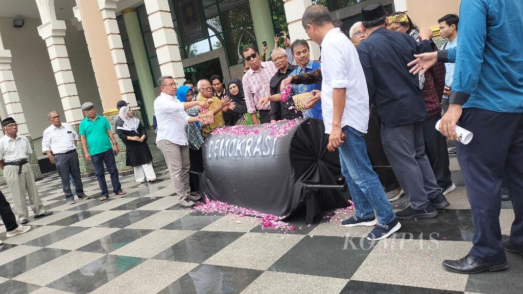 Sejumlah perwakilan dari dosen dan mahasiswa Universitas Islam Indonesia (UII) menaburkan bunga di atas keranda, sebagai simbol dari kematian demokrasi di Indonesia, Kamis (14/3/2024).