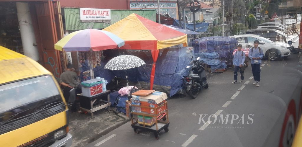 Activities on the roads and sidewalks on Jalan KH Mas Mansyur, Tanah Abang, Central Jakarta, Friday (5/5/2023). Sidewalks are closed for street vendors. Pedestrians must also use the bicycle path on the roadside.
