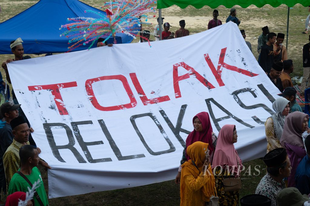 Warga membentangkan spanduk yang berisikan aspirasi menolak relokasi seusai pentas seni dan budaya Melayu di Dataran Muhammad Musa, Pulau Rempang, Batam, Kepulauan Riau, 9 November 2023.