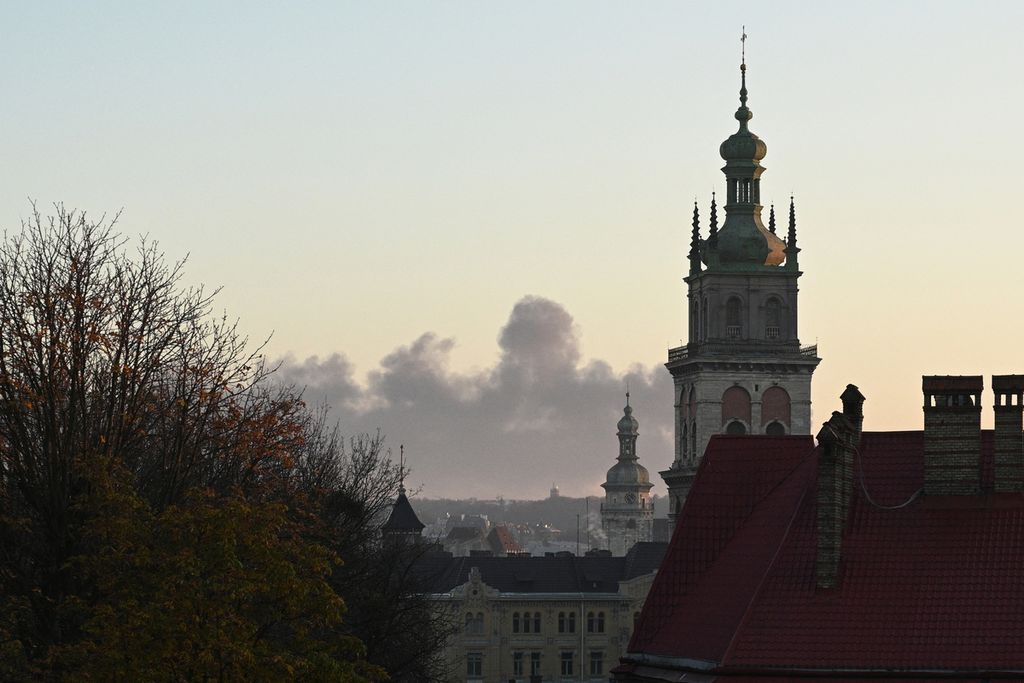 Asap membubung di kejauhan setelah militer Rusia menyerang kota Lviv, Ukraina, Selasa (15/11/2022). Perang Rusia-Ukraina ikut menekan pertumbuhan perdagangan global. 