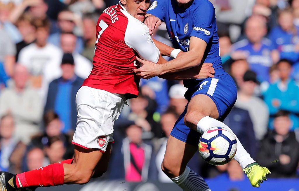 Pemain Arsenal, Alexis Sanchez (kiri)   terlibat dalam perebutan bola dengan pemain Chelsea, Andreas Christensen pada laga Liga Inggris di Stamford Bridge, London, Minggu (17/9) malam WIB. Kedua tim bermain seri 0-0. 