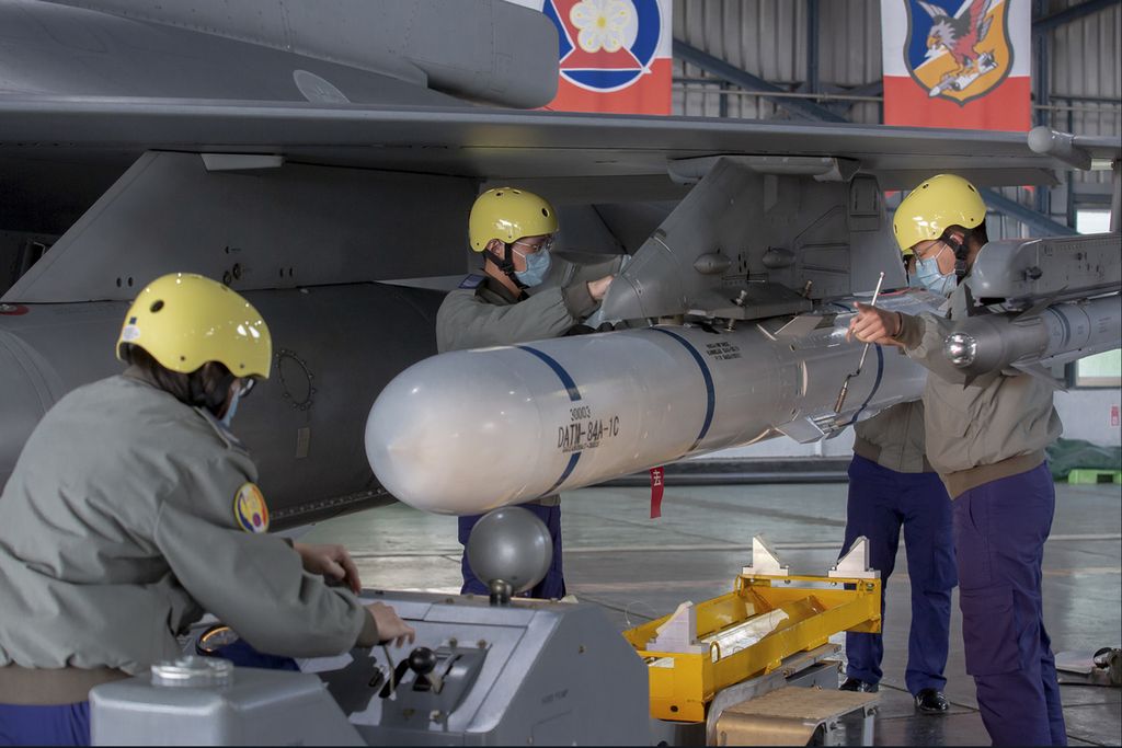 Dalam foto yang dirilis oleh Kantor Kepresidenan Taiwan ini, kru darat tengah memasang sebuah rudal pada sayap jet tempur F-16 saat kunjungan Presiden Taiwan Tsai Ing-wen di pangkalan militer di Chiayi, Taiwan, Jumat (6/1/2023). (Taiwan Presidential Office via AP)