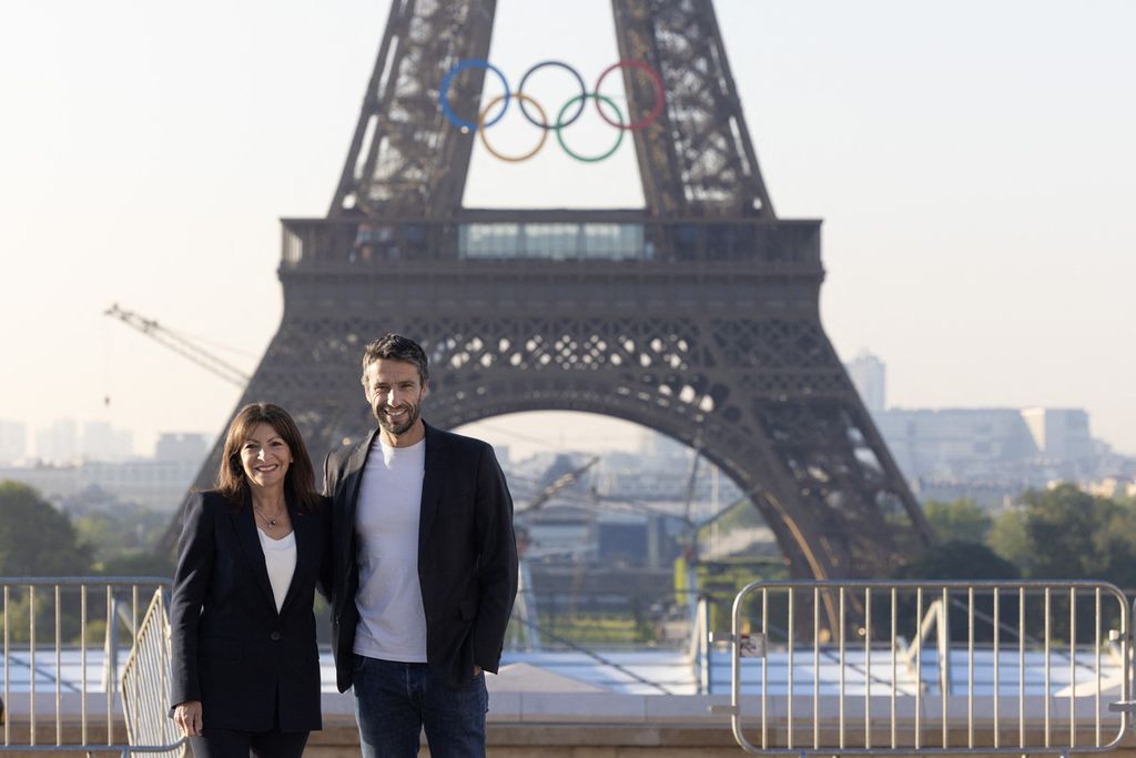 Wali Kota Paris Anne Hidalgo (kiri) dan Presiden Komite Penyelenggara Olimpiade dan Paralimpiade Paris 2024 Tony Estanguet berpose di depan Menara Eiffel setelah pemasangan cincin Olimpiade di menara untuk Olimpiade Paris 2024, Jumat (7/6/2024). 