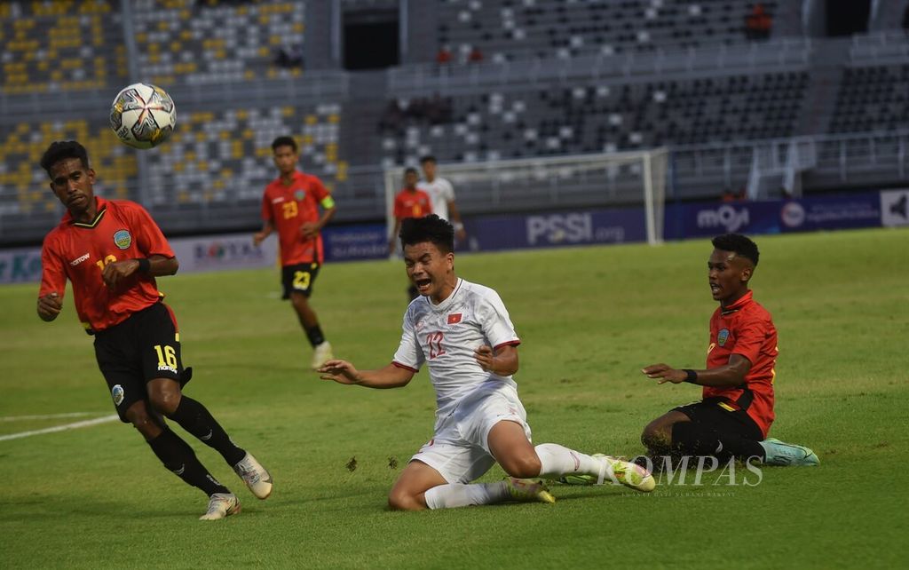 Pemain Vietnam Nguyen Hai Nam (tengah) terjatuh saat berebut bola dengan pemain Timor Leste pada babak kualifikasi Piala Asia U-20 di Stadion Gelora Bung Tomo, Kota Surabaya, Jawa Timur, Jumat (16/9/2022). Vietnam menang 4-0 melawan Timor Leste. 