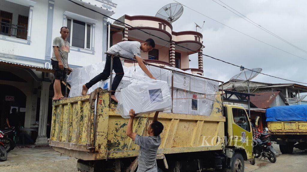 Pekerja gudang KPU Nias Selatan di Telukdalam, Nias Selatan, Sumatera Utara, sedang memasukkan logistik pemilu susulan untuk lima kecamatan, Senin (22/4/2019).