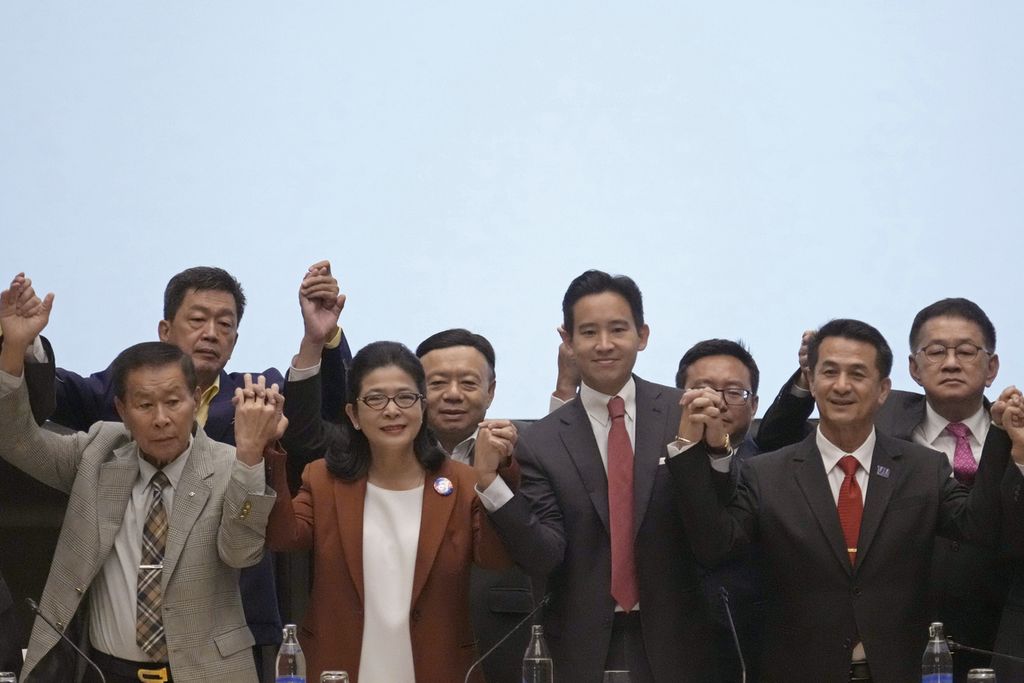 Pemimpin Partai Bergerak Maju (MFP) Pita Limjaroenrat (ketiga dari kiri) mengangkat tangan bersama para pemimpin partai lain saat konferensi pers di Bangkok, Thailand, 18 Mei 2023. 