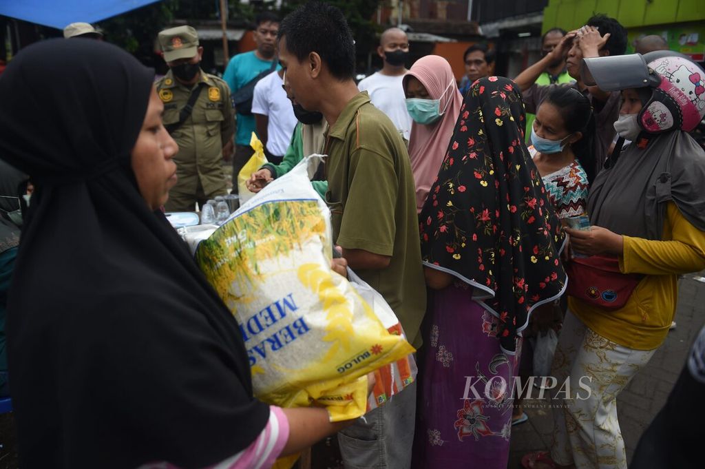 Warga membeli beras medium saat operasi pasar di Pasar Kembang, Surabaya, Minggu (5/2/2023). Operasi pasar berlangsung pada 4-5 Februari di 12 pasar di Kota Surabaya. Beras medium dijual Rp 46.000 per 5 kg. Warga dibatasi membeli hanya 10 kg beras.