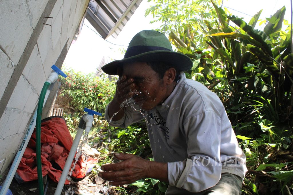 Didin (52), warga RT 003 RW 008, Kampung Karamat, Desa Sukamulya, Kecamatan Cugenang, Cianjur, membasuh mukanya setelah seharian bekerja sebagai tukang bangunan, Rabu (28/8/2024). Seumur hidupnya, baru kali ini Didin memiliki keran terpasang di rumahnya. 