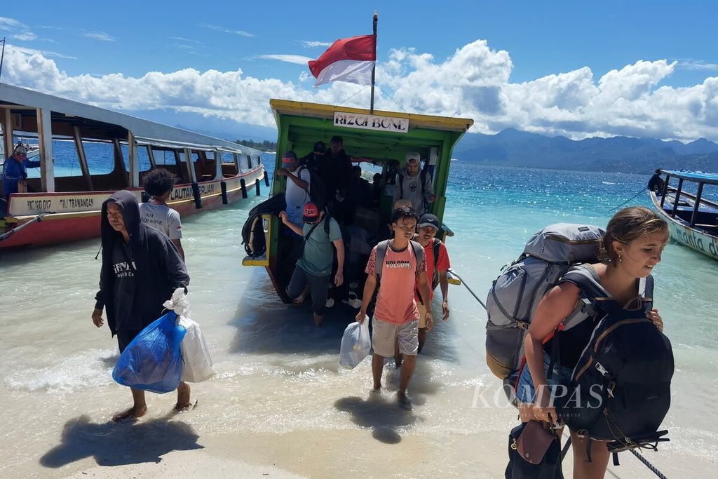 Wisatawan yang akan berlibur di Gili Trawangan, Lombok Utara, Nusa Tenggara Barat, turun dari kapal penyeberangan umum, Selasa (10/1/2023). 