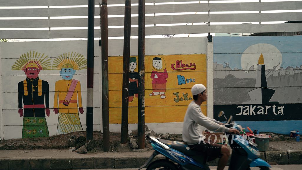 Warga melewati mural yang meramaikan HUT Ke-495 DKI Jakarta di Cipinang Besar Selatan, Jatinegara, Jakarta Timur, Minggu (19/6/2022). Pemerintah Provinsi DKI Jakarta menyambut hari jadi ke-495 dengan menggelar sejumlah acara sebulan penuh mulai 24 Mei sampai 25 Juni 2022. 
