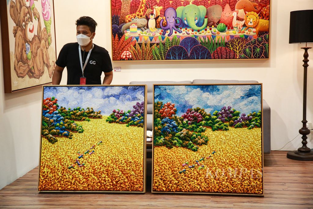 Petugas memperlihatkan lukisan di salah satu galeri yang ambil bagian dalam Art Jakarta 2022 di Jakarta Convention Center, Senayan, Jakarta, Jumat (26/8/2022). 
