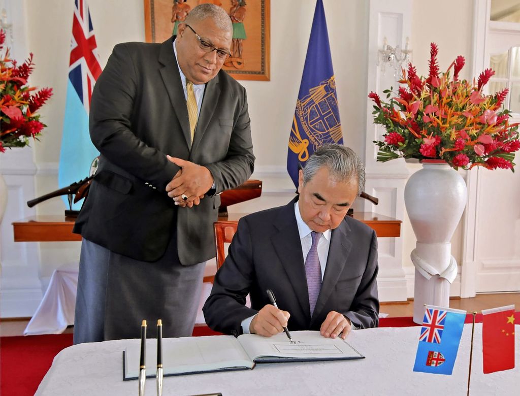 Foto yang dirilis Pemerintah Fiji ini menunjukkan Presiden Fiji, Ratu Wiliame Katonivere (kiri), menyaksikan Menteri Luar Negeri China Wang Yi menandatangani buku tamu di Gedung Negara di Suva, Fiji, Senin (30/5/2022). 