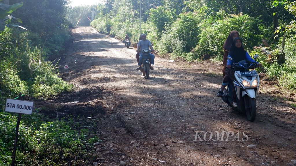 Warga melewati jalan yang menghubungkan Desa Benua Riam dengan Desa Artain dan Desa Apuai di Kecamatan Aranio, Kabupaten Banjar, Kalimantan Selatan, Sabtu (28/5/2022). 
