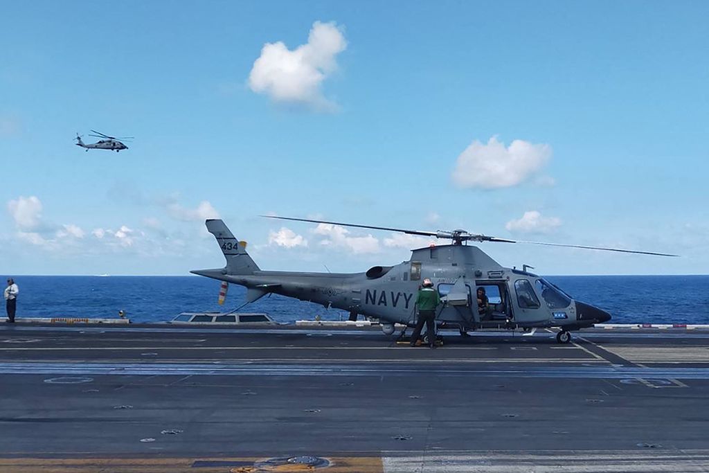 Foto dari Angkatan Bersenjata Filipina yang diambil pada 4 Januari 2024 menunjukkan seorang pilot melakukan pemeriksaan akhir pada helikopter Angkatan Laut Filipina, AW109, di atas dek kapal induk AS, USS Carl Vinson, saat latihan bersama di Laut China Selatan.