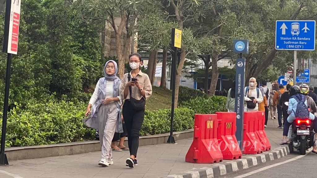 Masyarakat berjalan di kawasan Stasiun MRT Dukuh Atas, Jakarta, Minggu (20/8/2023). Sebagian dari mereka memakai masker untuk melindungi diri dari polusi udara.