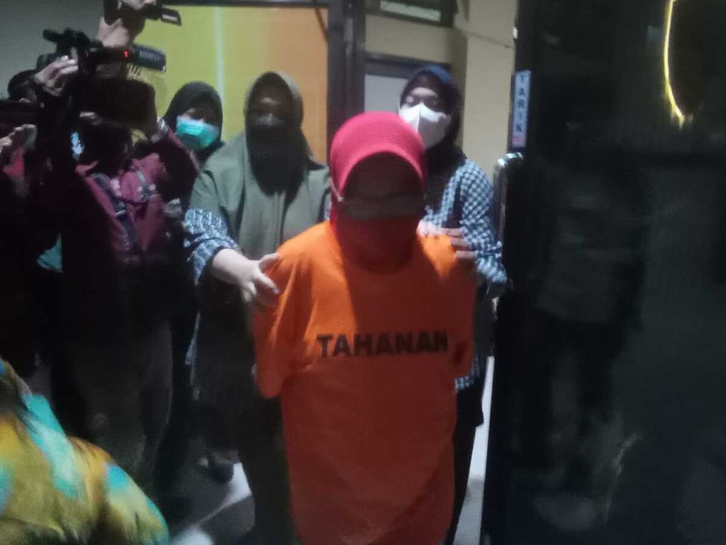 EW (46), pelaku kekerasan terhadap anak, saat digiring ke Polresta Bandar Lampung, Senin (21/2/2022) sore. 