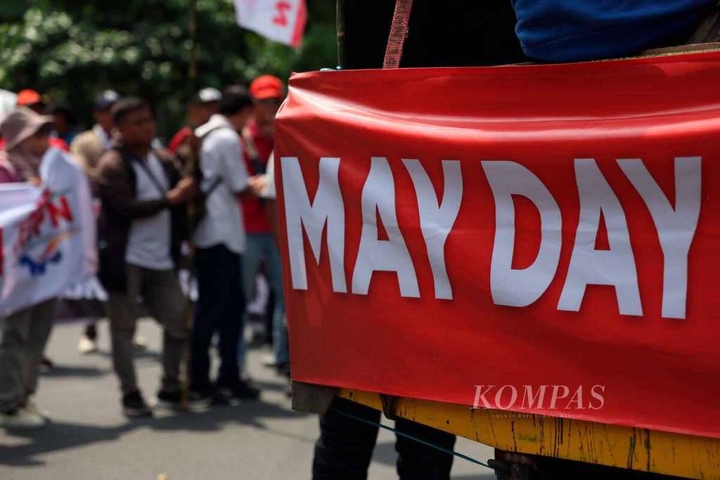 The May Day banner brought by activists to commemorate Labor Day during a solidarity action on Pahlawan Street, Semarang City, Central Java, on Wednesday (1/5/2024). Workers who were on holiday still held a labor solidarity action to demand their welfare and push for changes in government policies related to several laws that are not pro-workers.