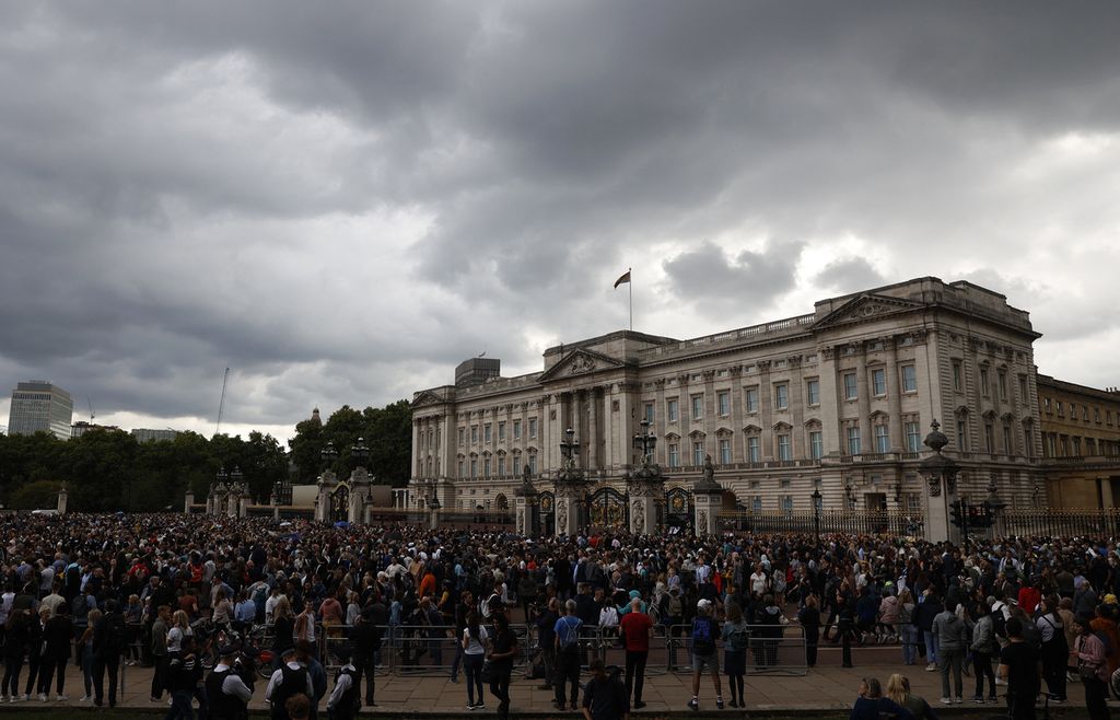 Masyarakat berkumpul saat bendera Royal Standard dikibarkan, mengisyaratkan pemimpin monarki berada di dalam Istana Buckingham di London, Jumat (9/9/2022), sehari setelah Ratu Elizabeth II wafat dalam usia 96 tahun.