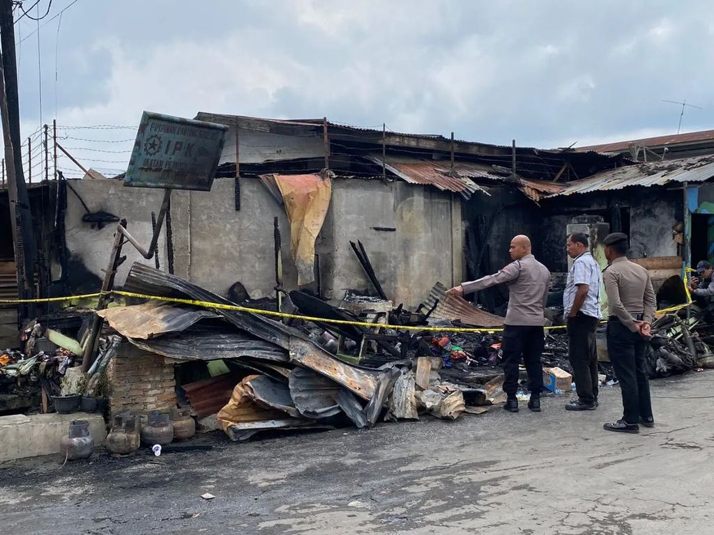 Pelaksana Harian Kepala Kepolisian Resor Tanah Karo Ajun Komisaris Besar Oloan Siahaan (kanan) menyaksikan lokasi kebakaran rumah yang menewaskan wartawan Tribratatv.com, Sempurna Pasaribu, dan tiga anggota keluarganya di Jalan Nabung Surbakti, Kecamatan Kabanjahe, Kabupaten Karo, Sumatera Utara, Kamis (27/6/2024).