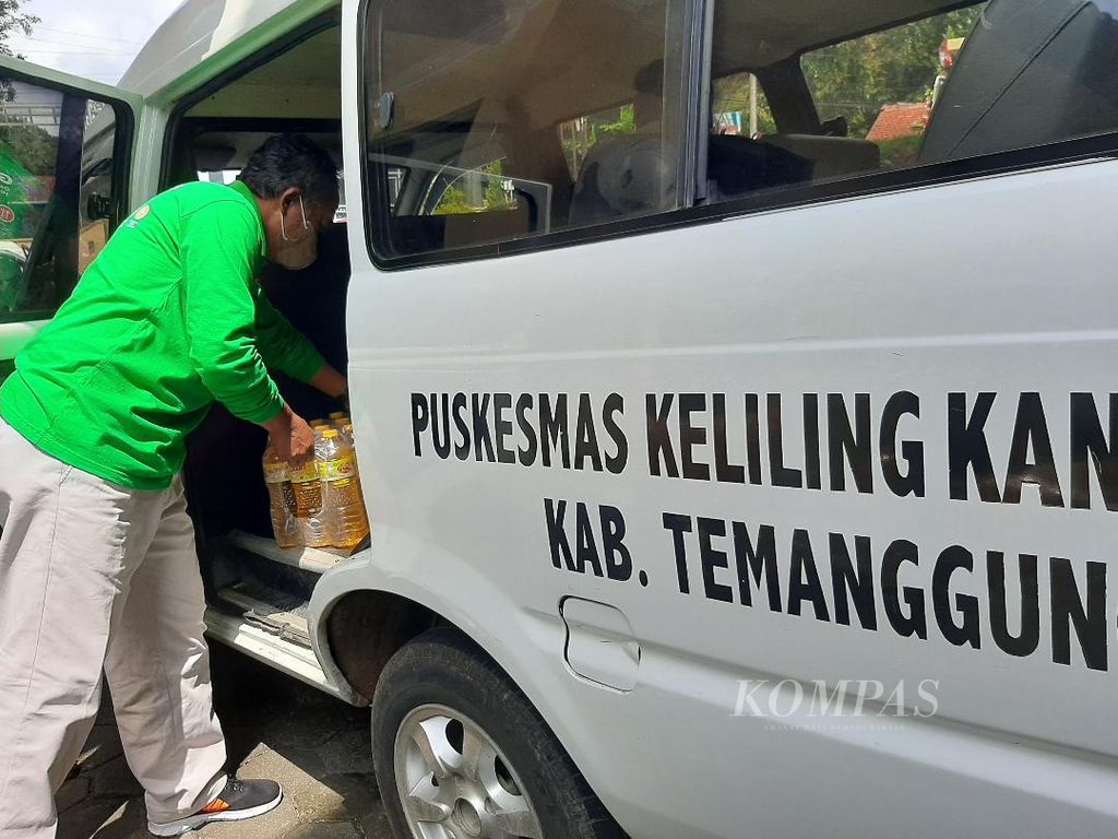 Seorang petugas memasukkan minyak goreng ke ambulans milik salah satu puskesmas di Kabupaten Temanggung, Jawa Tengah, Jumat (8/4/2022). Minyak goreng ini disiapkan sebagai hadiah bagi warga lansia yang melakukan vaksinasi.