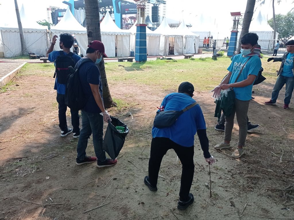Sukarelawan kebersihan memungut sampah yang dominan plastik dan puntung rokok di Pantai Festival Ancol, Jakarta Utara, Sabtu (4/6/2022). Area ini jadi salah satu tempat menonton melalui layar lebar dan ada panggung hiburan serta gerai UMKM.