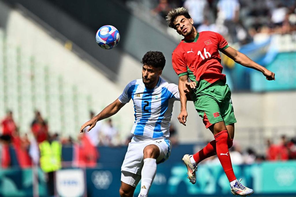 Bek Argentina, Marco Di Cesare, dan penyerang Maroko, Abde Ezzalsouli, berduel di udara dalam pertandingan penyisihan Grup B Olimpiade Paris 2024 di Stadion Geoffroy-Guichard, Saint Etienne, Rabu (24/7/2024). 