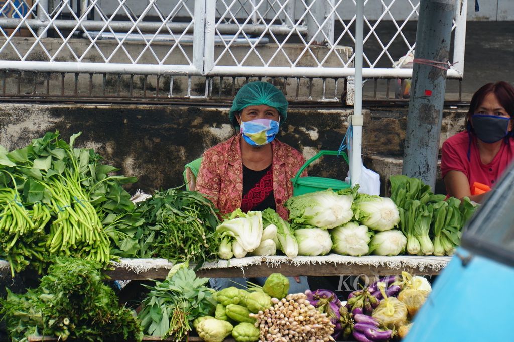 Pedagang di Pasar Pinasungkulan, Karombasan Utara, Wanea, Manado, Sulawesi Utara, mengenakan masker dan jaring rambut (hairnet) ketika berdagang, Selasa (19/5/2020). Pasar Pinasungkulan adalah salah satu lokasi transmisi Covid-19 di Manado.