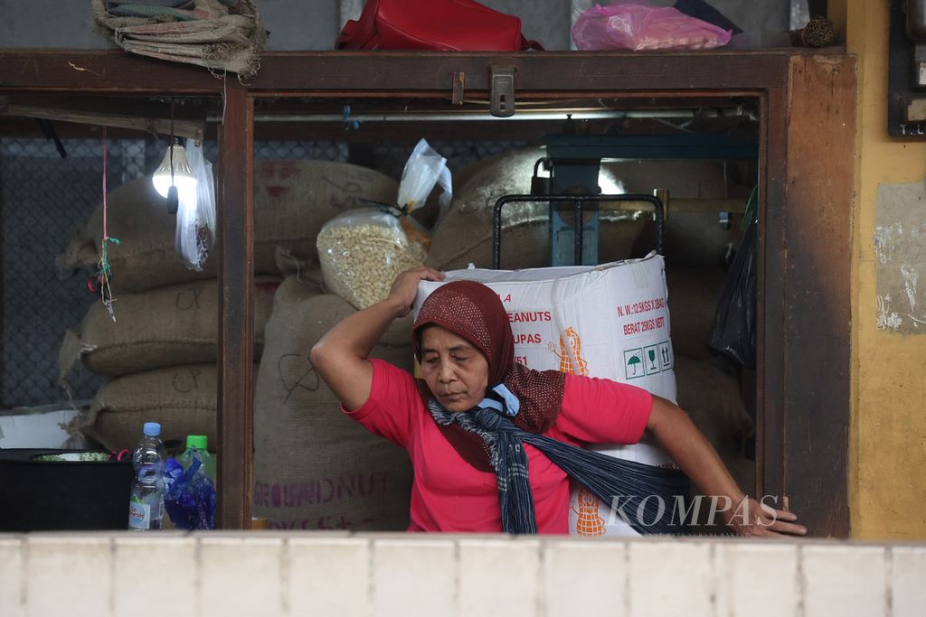 Buruh gendong membawa barang saat bekerja di Pasar Beringharjo, Yogyakarta, Senin (6/3/2023).