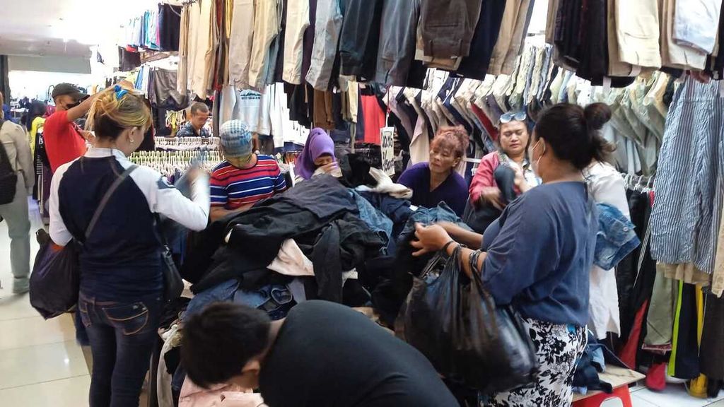 Para pembeli sedang memilih baju bekas impor yang laik pakai pada Jumat (23/12/2022) di lantai dua Pasar Senen Blok III Jakarta Pusat. 