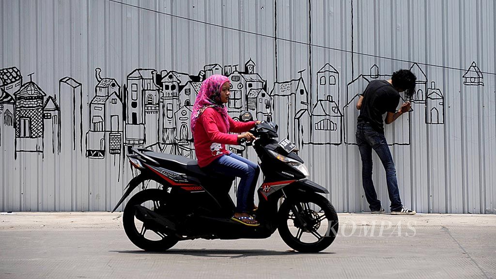 Seniman menyelesaikan pembuatan mural yang menggambarkan lanskap kota pada dinding penutup proyek apartemen di Banyumanik, Kota Semarang, Jawa Tengah, Jumat (24/2). Seni mural telah menjadi representasi budaya urban yang membawa pesan sosial dengan beragam permasalahan kota.