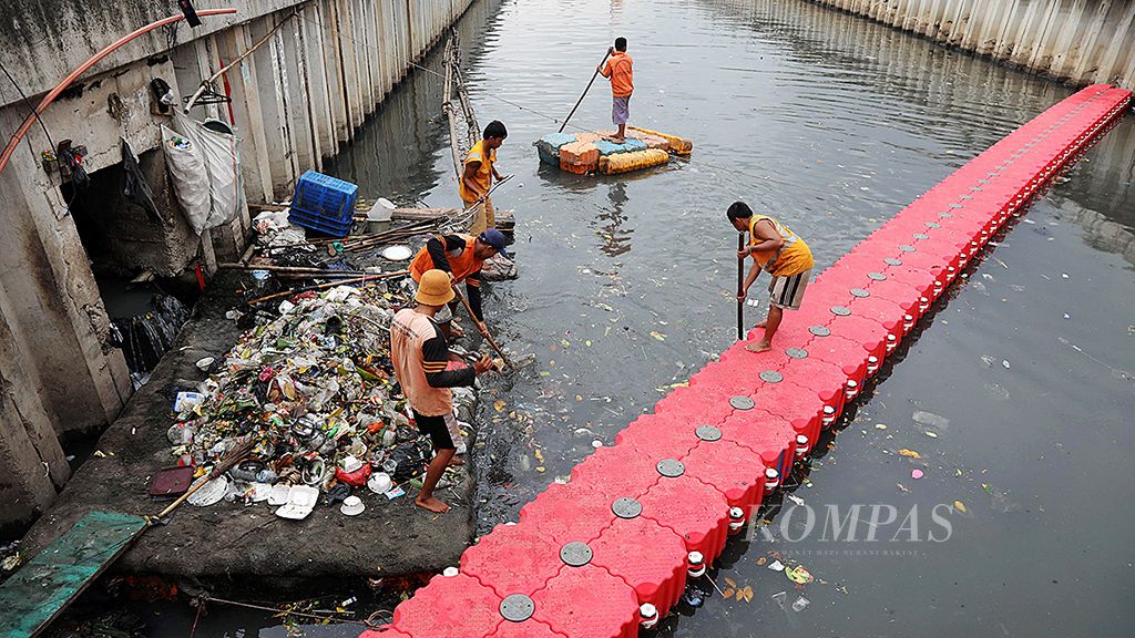 Petugas Unit Pengelola Kebersihan  Badan Air Jakarta Pusat membersihkan sampah di Kali Sentiong, Jakarta Pusat, Kamis (16/11). Limbah domestik, endapan lumpur dan sampah yang dibuang masyarakat ke kali menghambat arus aliran sungai dan berpotensi meluap saat banjir.