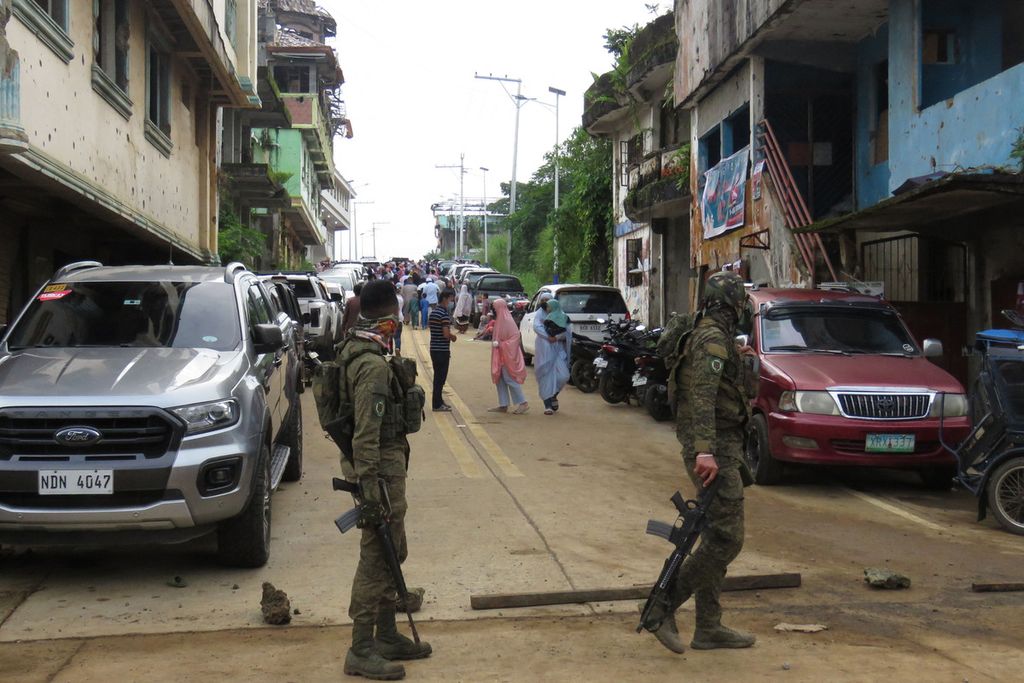 Dua petugas keamanan bersenjata berjaga di sekitar lokasi masjid yang digunakan warga Muslim untuk melaksanakan shalat Idul Fitri di kota Marawi, Senin (2/5/2022). Dua kelompok politik Muslim, MILF dan MNLF, menyatakan dukungan terhadap Leni Robredo, calon presiden Filipina, dan Sara Duterte-Carpio, calon wakil presiden Filipina. 