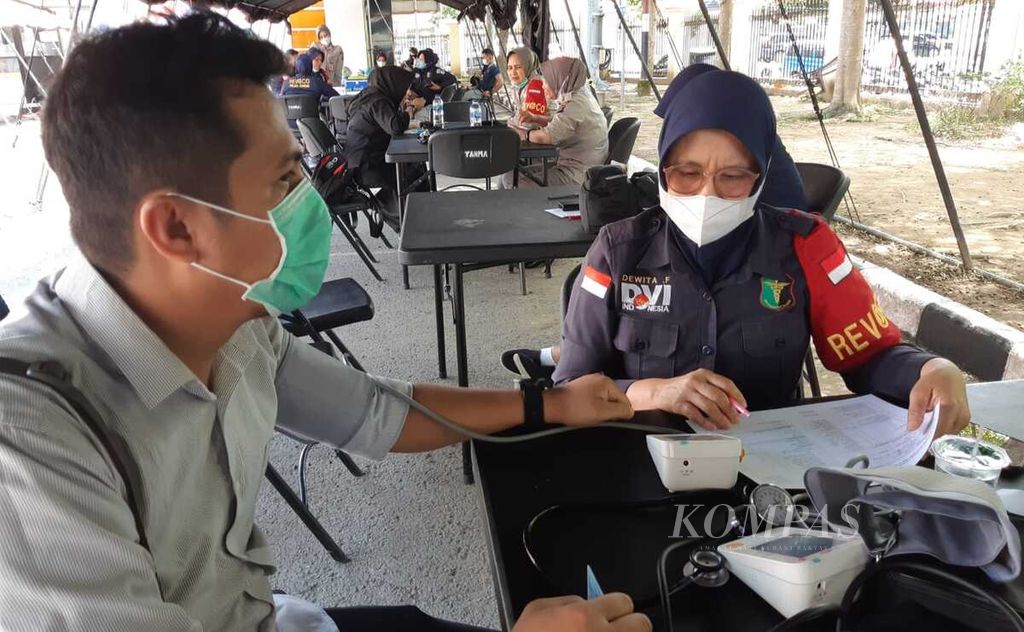 Seorang jurnalis menjalani pengukuran tekanan darah sebelum mendapatkan suntikan vaksinasi penguat di Markas Polda Sumatera Barat, Padang, Sumbar, Kamis (3/2/2022). Vaksinasi penguat diharapkan semakin meningkatkan imun tubuh terhadap Covid-19.