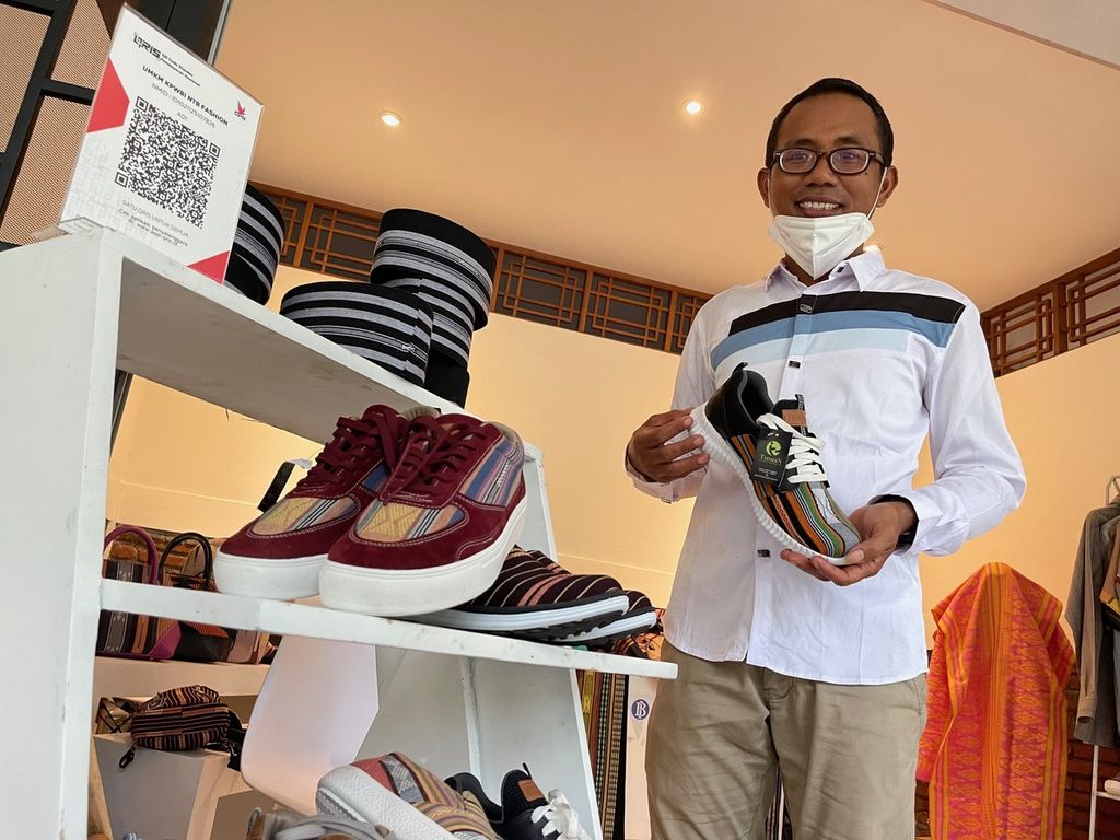 Ketua Sentosa Sasak Tenun M Maliki memperlihatkan produk sepatu tenun saat dipamerkan dalam kunjungan Presiden Joko Widodo di area Bazzar Mandalika, Kawasan Ekonomi Khusus Mandalika, Kuta, Pujut, Lombok Tengah, Kamis (13/1/2022).