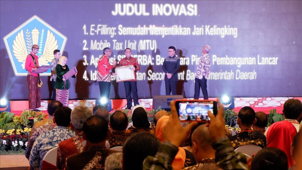Menteri Pendayagunaan Aparatur Negara dan Reformasi Birokrasi (PANRB) Syafruddin (kanan) menyerahkan penghargaan Top 99 Inovasi Pelayanan Publik, di Kota Semarang, Jawa Tengah, Kamis (18/7/2019). Jateng menjadi provinsi dengan inovasi pelayanan publik terbanyak pada 2019.